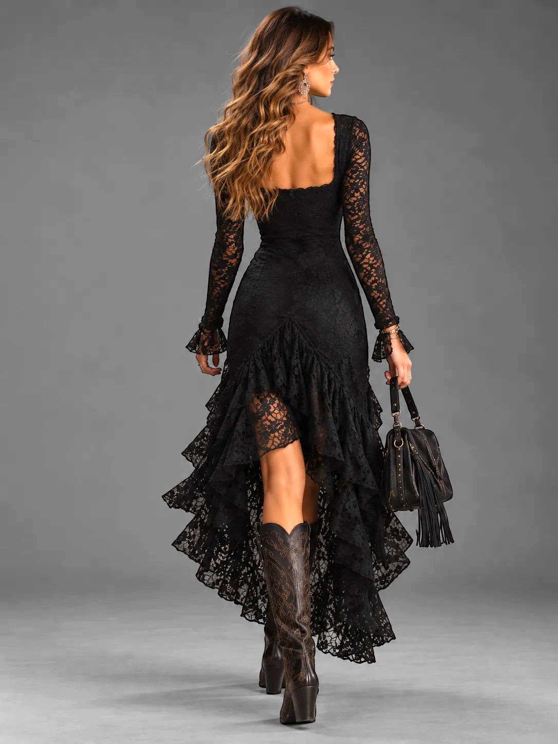 Vestito Alessia Vellani nero in pizzo con maniche lunghe, gonna asimmetrica a balze e stivali texani
